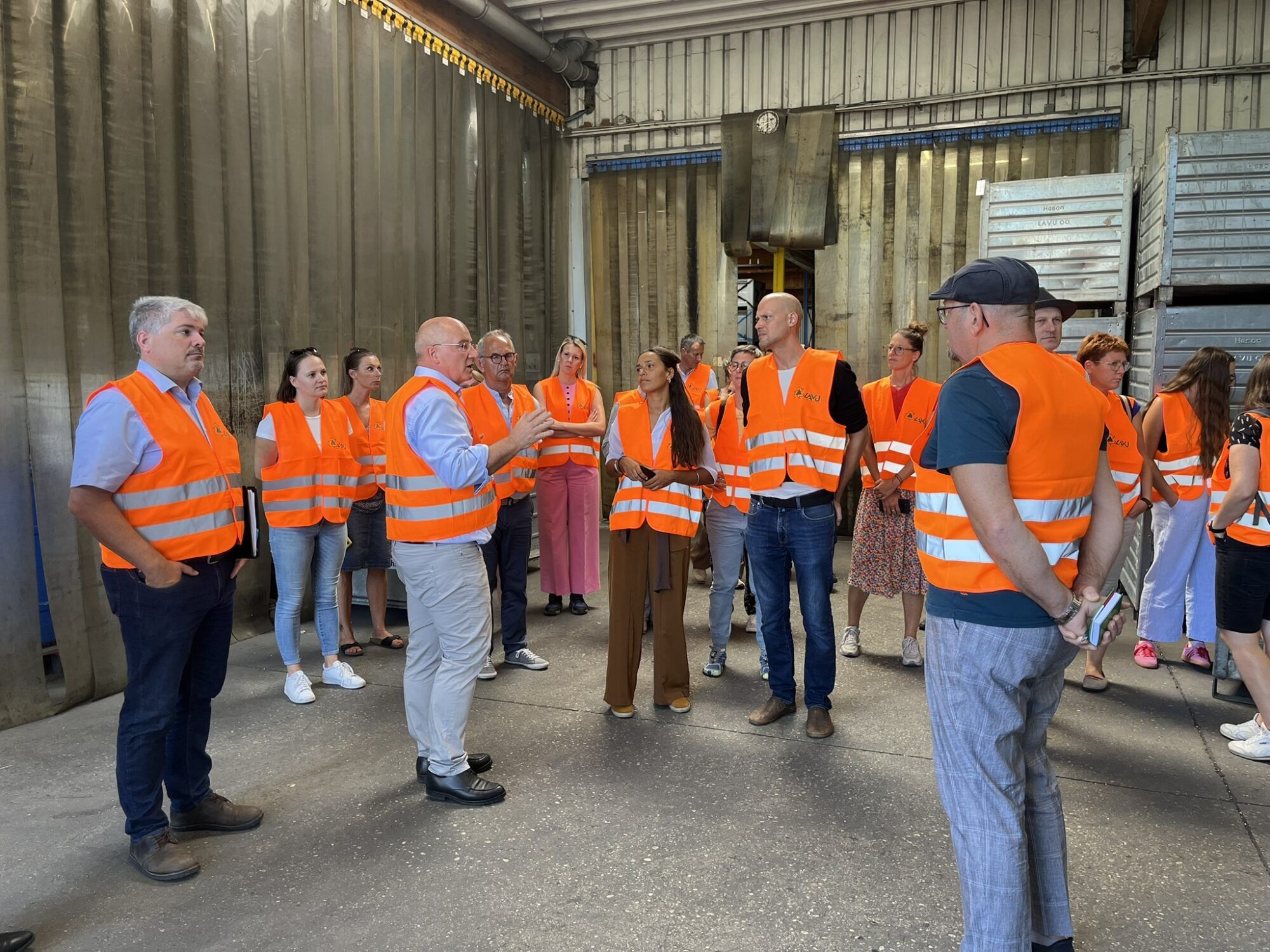 ReVital Interessenten in einer Gruppe zusammenstehend in orangen Warnwesten