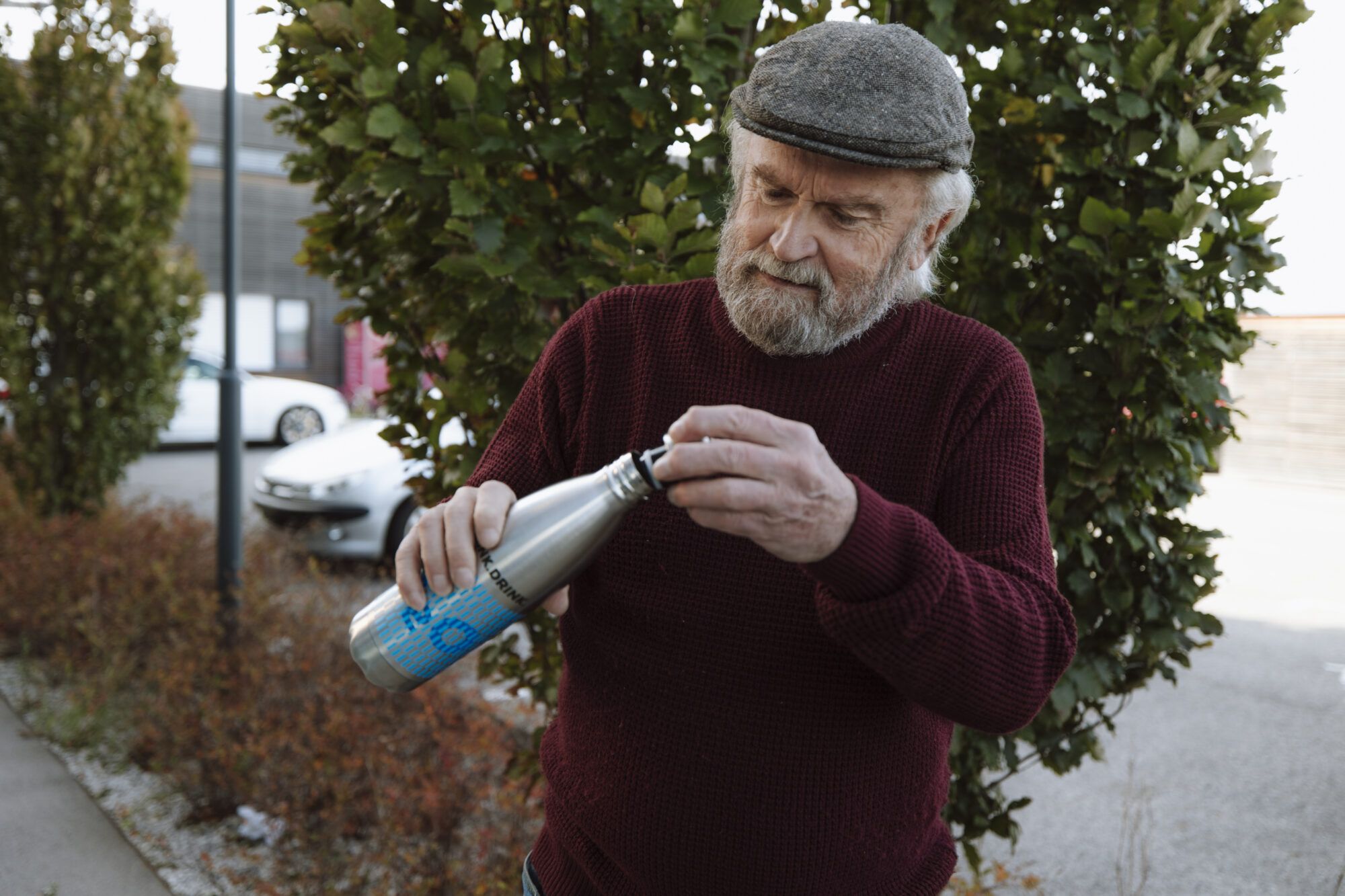&Auml;lterer Herr schlie&szlig;t eine Mehrweg-Edelstahl-Trinkflasche.